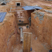 workers set up trench wall for piping work workers set up trench wall for piping work
