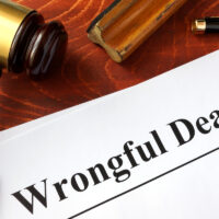 wrongful death document, gavel, spectacles and pen on table