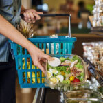 a woman buying a salad at a deli