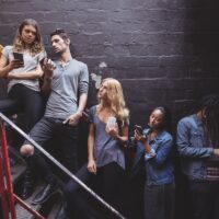 people using phones while in line for nightclub