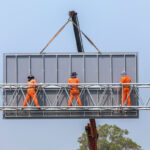 construction workers on billboard catwalk