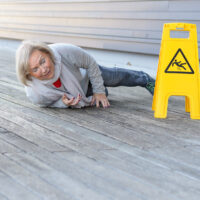 Senior woman slipping and falling on a wet surface