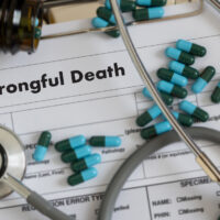 Wrongful Death form with stethoscope and pills on top