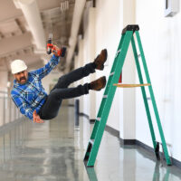 Construction worker in midst of falling off ladder