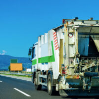 trash hauler driving on road
