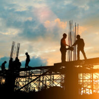 Silhouette of construction team working on roof