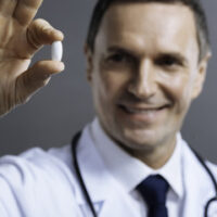 Doctor holding a pill