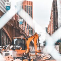 Construction scene in New York City. Excavator and several tools of construction. Edited with orange and teal colors.