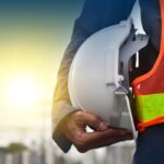 Technician holding white hat safety hard hat sunlight background