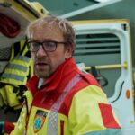 Middle Aged Paramedic Standing At the Back of The Ambulance Car,