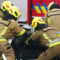 Firefighters cutting car doors to rescue viction of the car crash accident. High quality photo