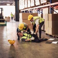 Industrial worker injured in the warehouse, factory while co-worker try to help, factory safety, construction zone, accident at factory work.