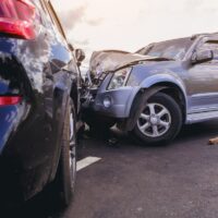 Car crash dangerous accident on the road. SUV car crashing beside another one on the road.