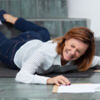 mature businesswoman falling on stairs inside office building