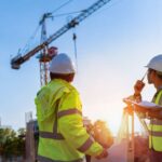 Construction engineers discussion with architects at construction site or building site of highrise building with Surveying for making contour plans is a graphical representation of the lay in land.