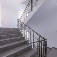 Modern stair case between floors. Stairs with metallic rail in modern building