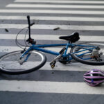 Blue bicycle and purple helmet near pedestrian crossing, car partially visible Blue bicycle and purple helmet near pedestrian crossing, car partially visible