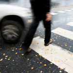Man on pedestrian crossing in danger of being hit by car Man on pedestrian crossing in danger of being hit by car