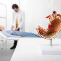 Gastroenterologist consultation, treatment of stomach diseases and ulcers. Doctor palpates woman patient abdomen and examines belly at clinic Gastroenterologist consultation, treatment of stomach diseases and ulcers. Doctor palpates woman patient abdomen and examines belly at clinic