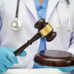 Doctor holding judge gavel, forensic medicine, medical law and crime justice concept.