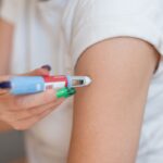 girl injects the drug Ozempic into her arm for weight loss at home.