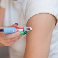 girl injects the drug Ozempic into her arm for weight loss at home.