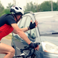 A man on a bicycle confronts a vehicle blocking his way A man on a bicycle confronts a vehicle blocking his way