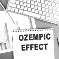 OZEMPIC EFFECT text on a notebook with keyboard and chart OZEMPIC EFFECT text on a notebook with keyboard and chart