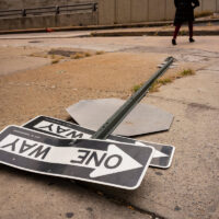 Fallen traffic sign on a concrete sidewalk street corner in the Hell’s Kitchen neighborhood of New York City. Fallen traffic sign on a concrete sidewalk street corner in the Hell’s Kitchen neighborhood of New York City.