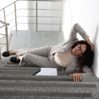 Woman with injured head on stairs in building after fall. Dangerous accident Woman with injured head on stairs in building after fall. Dangerous accident
