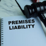 Concept of Premises Liability write on book with gavel isolated on Wooden Table.