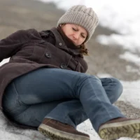 young woman has an accident on a icy way with black ice