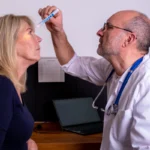 Eye examination. Doctor checking eyes for reaction to light, dilation of the pupil during a FAST test. Light sensitivity, Laser eye surgery.