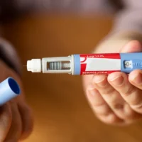 person preparing to inject semaglutide