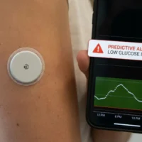 person-managing-blood-sugar-levels-with-a-wearable-sensor-device-and-smartphone-digital-application-for-remote-health-monitoring